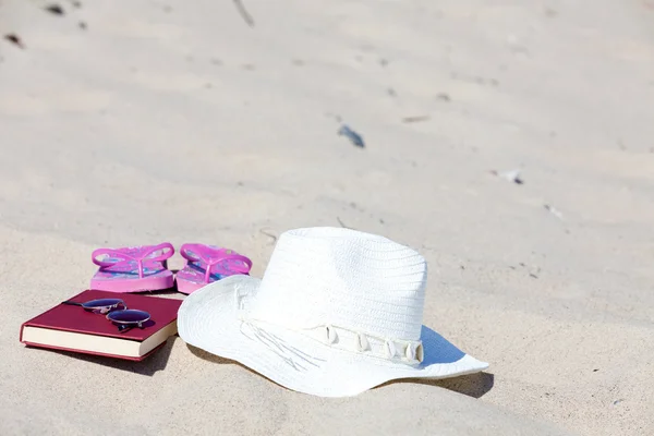 Avec le chapeau de paille et un livre sur la plage — Photo
