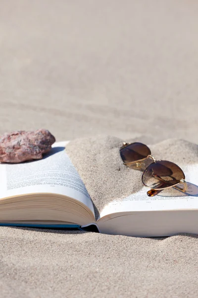 Okulary leży na książkę otwarty na plaży — Zdjęcie stockowe