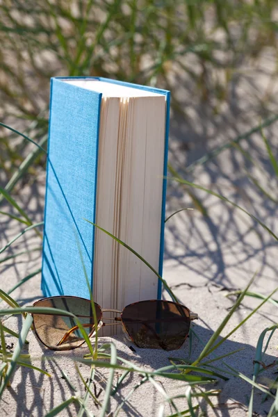 Un libro con gafas de sol en la arena de una duna —  Fotos de Stock