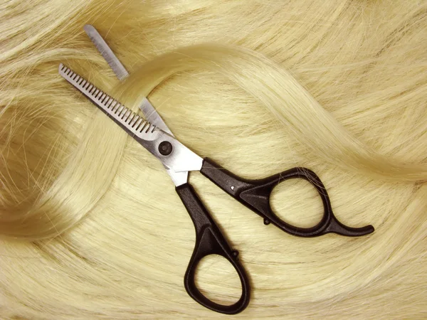Scissors in blond hair — Stock Photo, Image