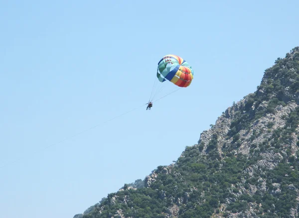 Hombre volando en un paracaídas en el cielo — Foto de Stock