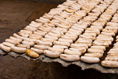 Outdoor drying of peeled bananas clipart