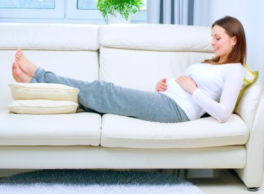 Pregnant Woman Resting on the Sofa at Home clipart