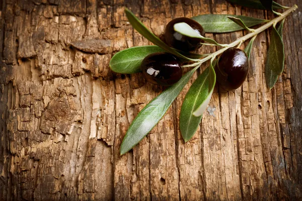 Oliven über altem Holz Hintergrund — Stockfoto