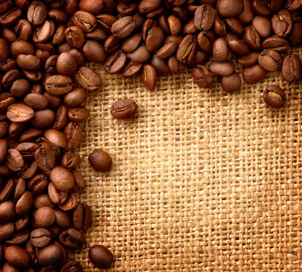 Koffie boordmotief. bonen over jute achtergrond — Stockfoto