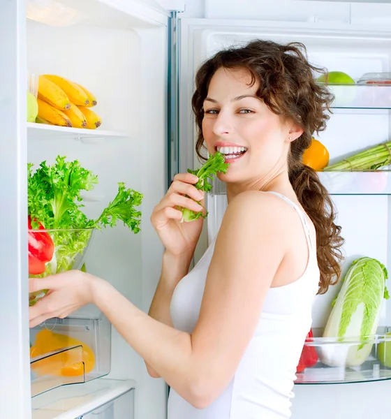 Hermosa mujer joven cerca del refrigerador con comida saludable —  Fotos de Stock