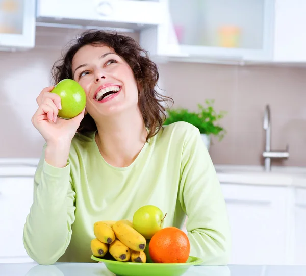 Concepto de dieta. Mujer joven riéndose come fruta fresca —  Fotos de Stock