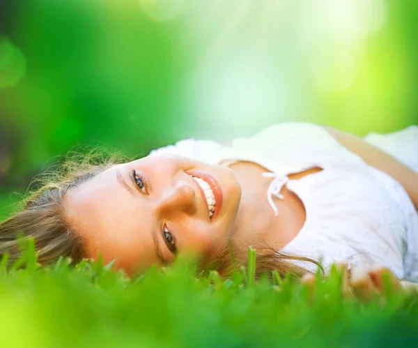 Lente meisje liggend op het veld. geluk — Stockfoto