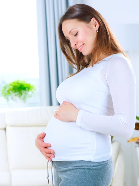 Mujer joven embarazada en casa. Feliz embarazo. —  Fotos de Stock