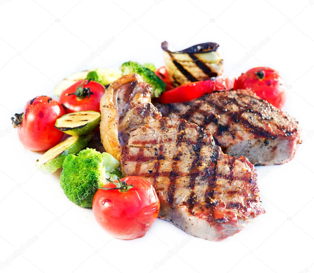 grilled beef steak with vegetables over white background |图库
