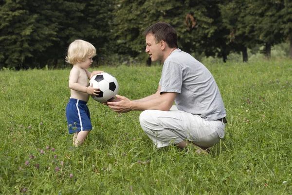 Father and his son with their ball in the park — Stock Photo, Image