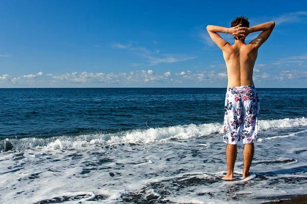 stock image Man wearing swimming trunks on the beach