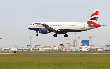 Lisbon Airport, 19 th May 2012. British airways aicraft landing with airport buildings in bakground clipart