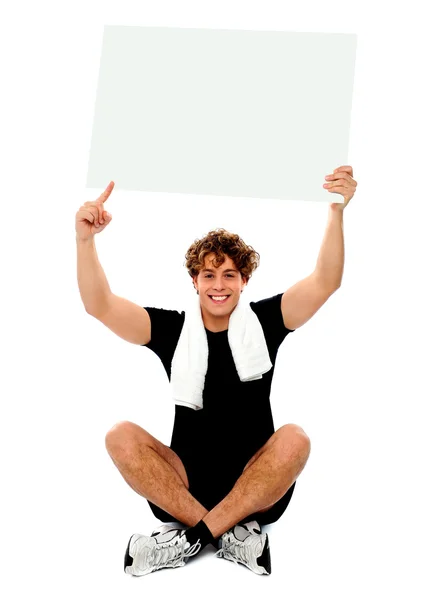 Atleta apuntando hacia el anuncio de banner en blanco —  Fotos de Stock