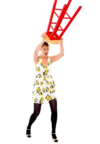 Frustrated woman breaking stool — Stock Photo, Image