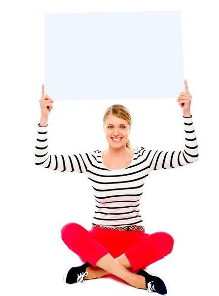 Sitzende Frau zeigt leere Plakatwand — Stockfoto