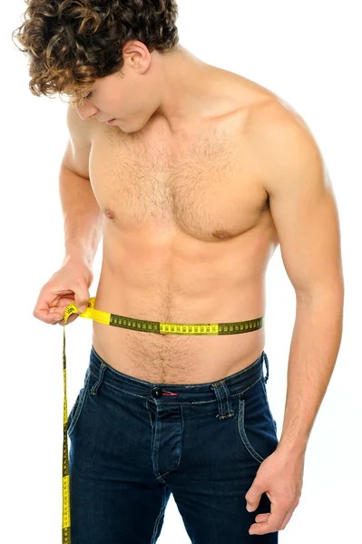 Muscular man measuring his waist — Stock Photo, Image