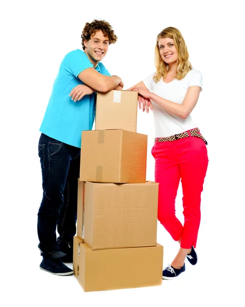 Adolescente casal posando ao lado de caixas de papelão — Fotografia de Stock