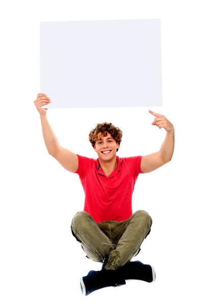 Koele kerel wijst naar witte lege billboard — Stockfoto