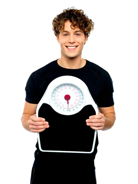 Attractive athlete showing weighing scale — Stock Photo, Image
