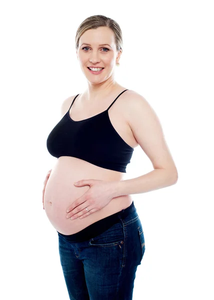 Smiling pregnant woman caressing her belly — Stock Photo, Image