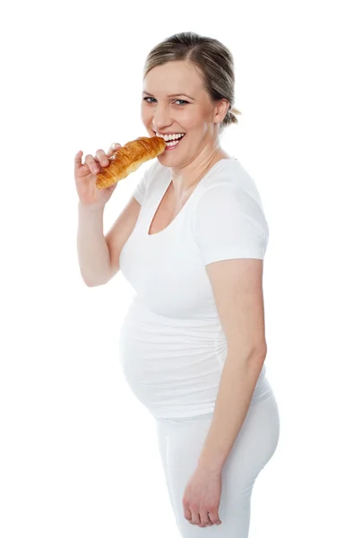 Беременная женщина ест фаст-фуд — стоковое фото