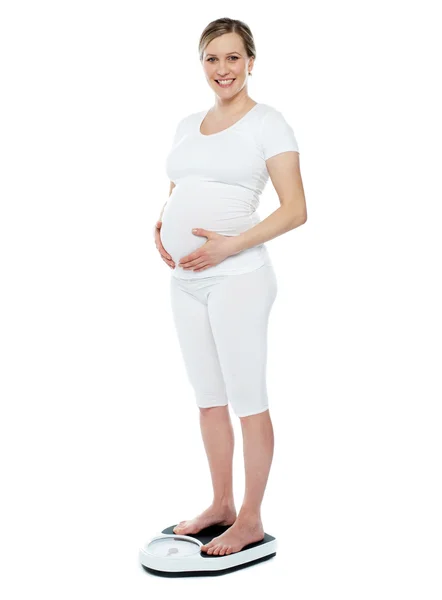 Mulher grávida medindo seu peso — Fotografia de Stock