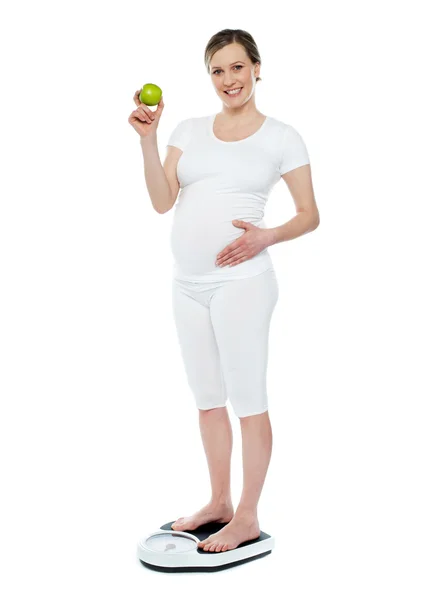 Mulher grávida em pé na máquina de pesagem — Fotografia de Stock