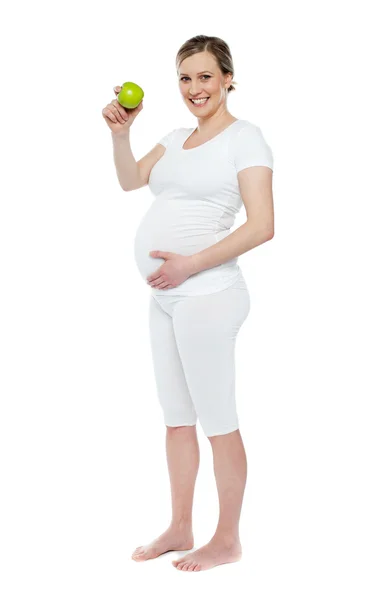 Mulher grávida mostrando maçã verde fresca — Fotografia de Stock