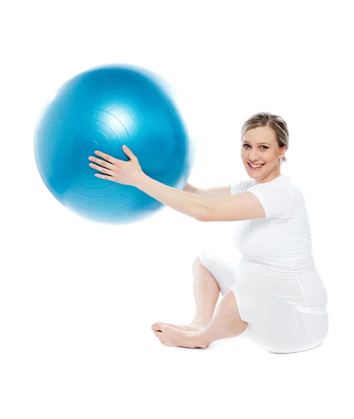 Беременная женщина играет с мячом для упражнений — стоковое фото
