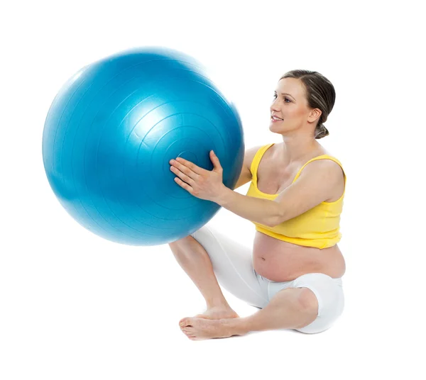 Mulher grávida excercises com uma bola de ginástica — Fotografia de Stock