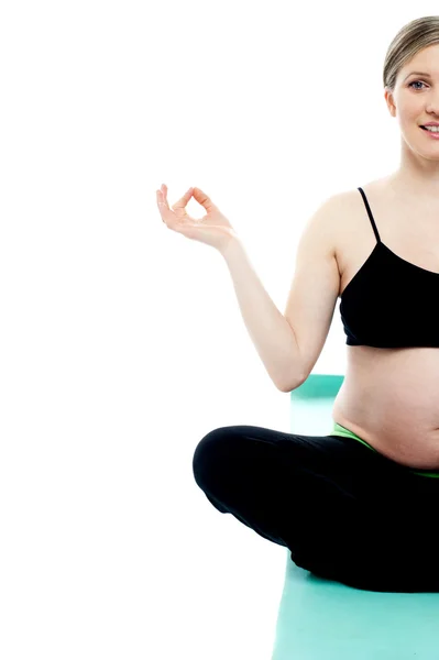 Cropped image of a pregnant lady doing yoga — Stock Photo, Image