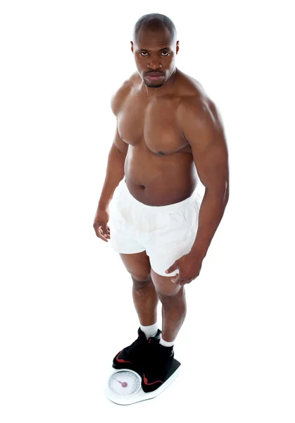 Muskularny mężczyzna stojący na elektroniczne wagi mechaniczne — Zdjęcie stockowe