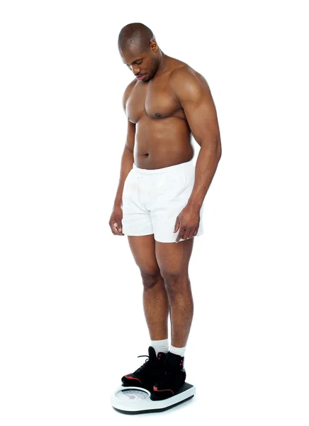 Atleta medindo seu peso na máquina de pesagem — Fotografia de Stock