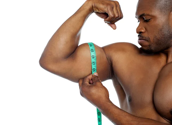 Handsome guy measuring his biceps — Stock Photo, Image
