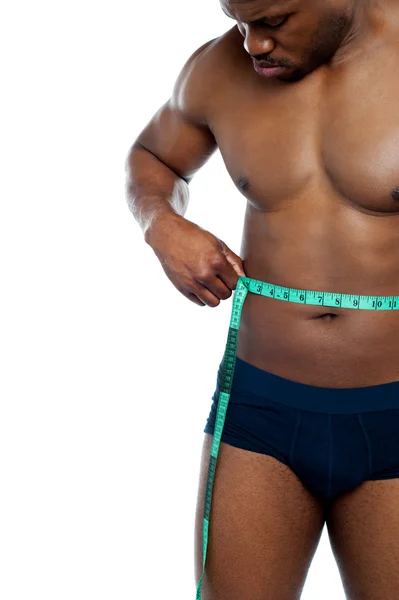 Homem muscular medindo sua cintura — Fotografia de Stock