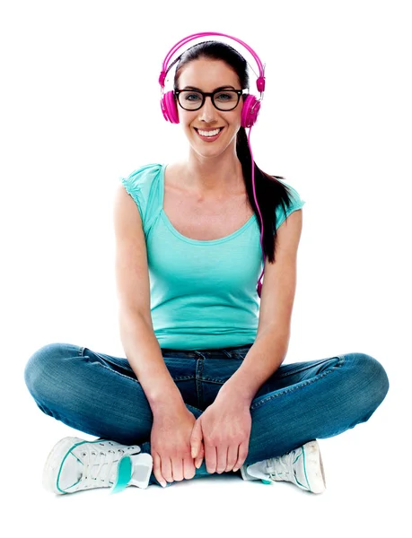 Tonåring sitter på golvet och lyssnar musik — Stockfoto
