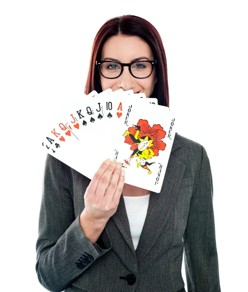 Señora corporativa escondiendo su sonrisa jugando a las cartas —  Fotos de Stock