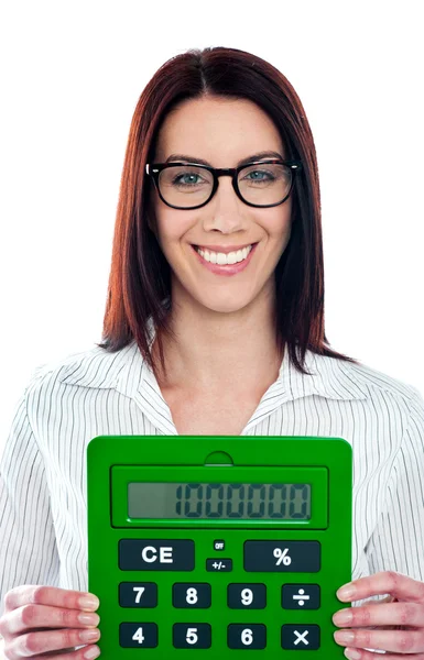 Усміхнена корпоративна дама показує зелений калькулятор — стокове фото