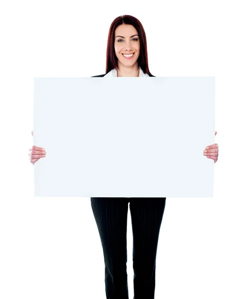 Caucasian businesswoman holding a blank billboard — Stock Photo, Image