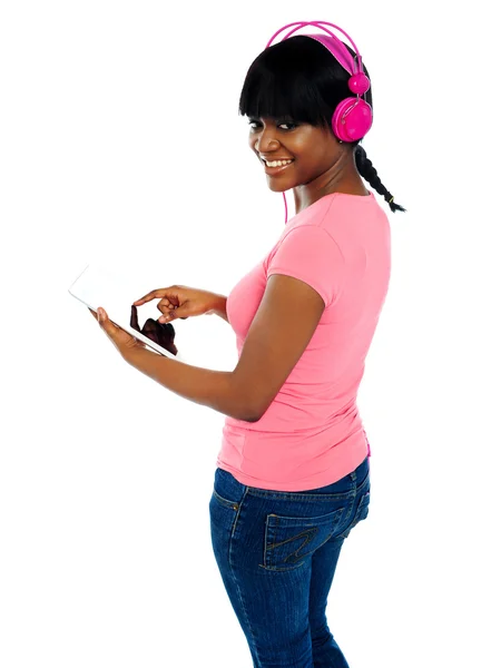 Menina ouvindo música via tablet portátil — Fotografia de Stock