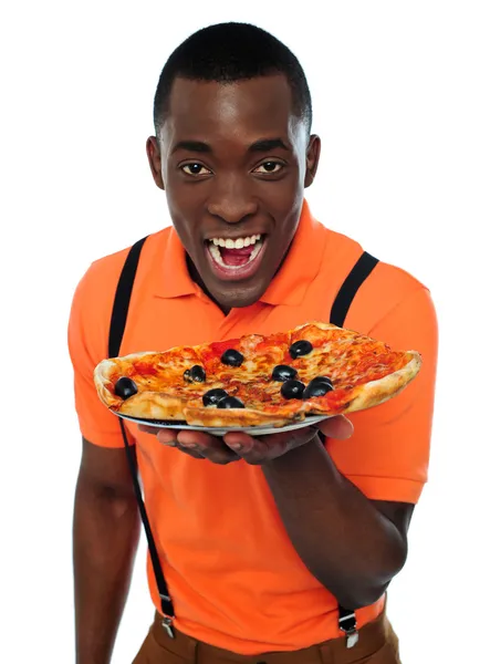 Menino de uniforme oferecendo pizza — Fotografia de Stock