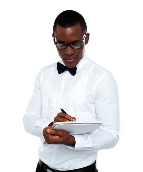 Confident young man writing on notepad — Stock Photo, Image