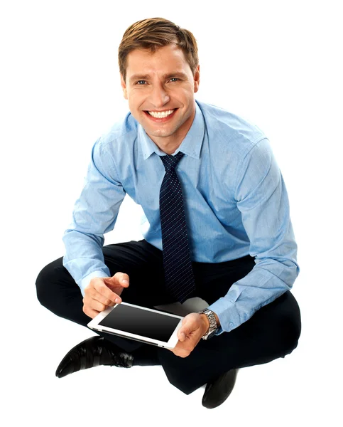 Muž sedí na podlaze pomocí dotykové obrazovky zařízení — Stock fotografie