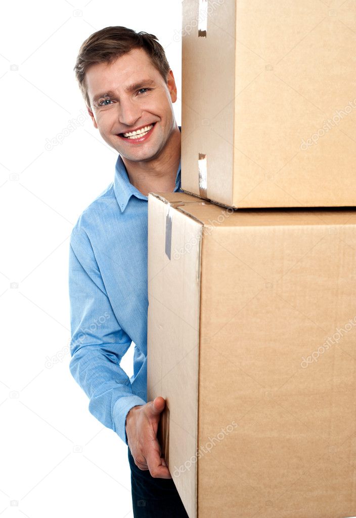 Smiling young man holding cardboard boxes