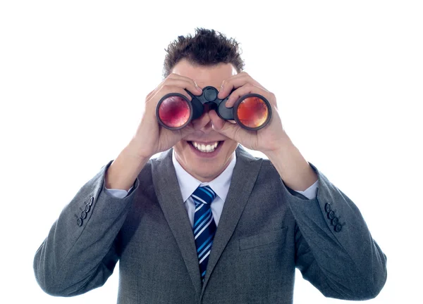 Uomo d'affari sorridente guarda attraverso binocoli — Foto Stock