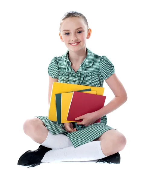 Menina bonita segurando livros escolares — Fotografia de Stock