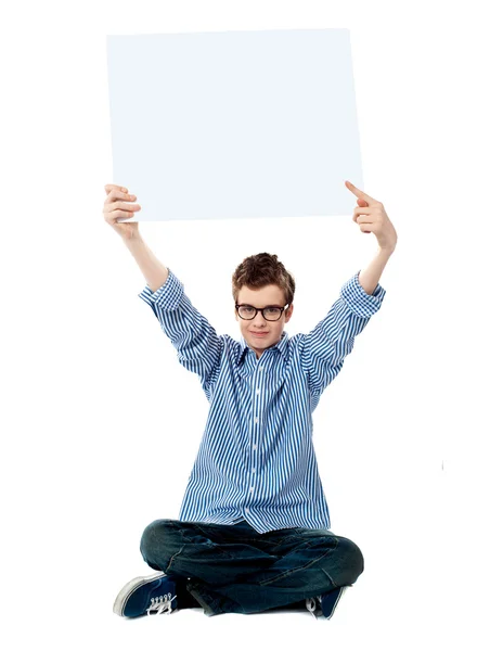 Pojke pekar mot vit blank skylt — Stockfoto