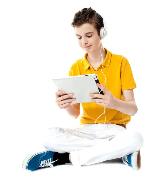 Niño sentado viendo vídeo en la tableta — Foto de Stock