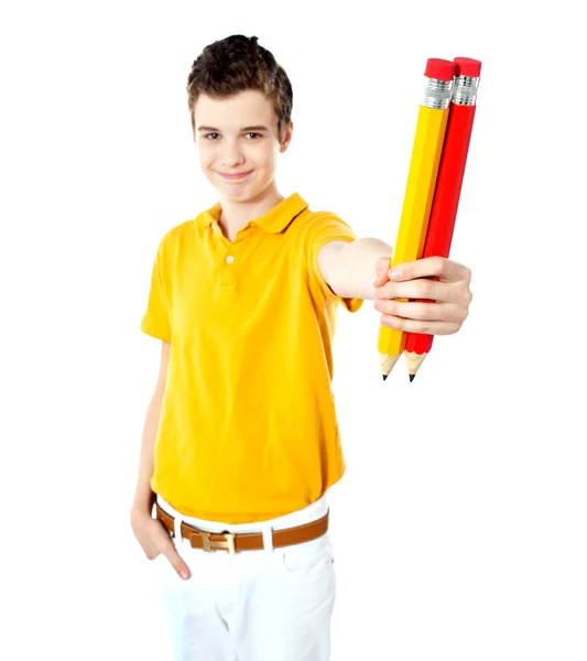 Stijlvolle jongen tonen twee grote potloden — Stockfoto